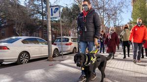 Alberto, el primer ciego sin manos que cuenta con un perro guía. En las imágenes, paseando por Teruel con el can.