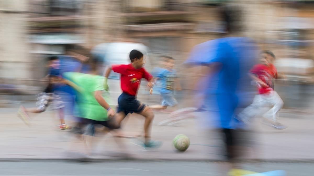 Unos chicos juegan a fútbol en una plaza del Poble Sec. Unos chicos juegan a fútbol en una plaza del Poble Sec.