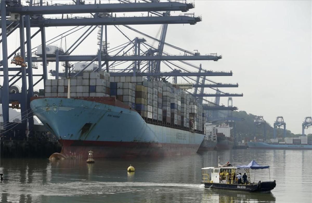 Un barco carga contenedores al lado del nuevo Canal de Panamá. Un barco carga contenedores al lado del nuevo Canal de Panamá.