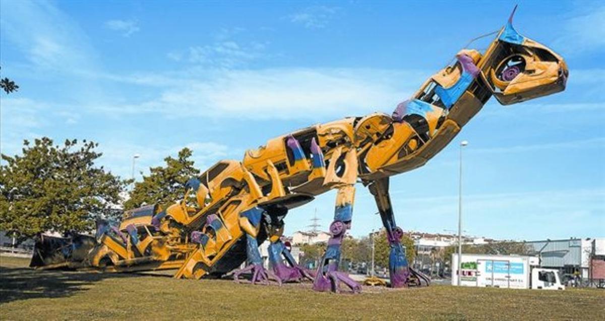 Amo y señor de la rotonda. ’Dino’, la escultura de Roc Alabern hecha con coches, en su glorieta, el viernes.