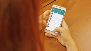 Una mujer consulta sus conversaciones y grupos de Whatsapp.