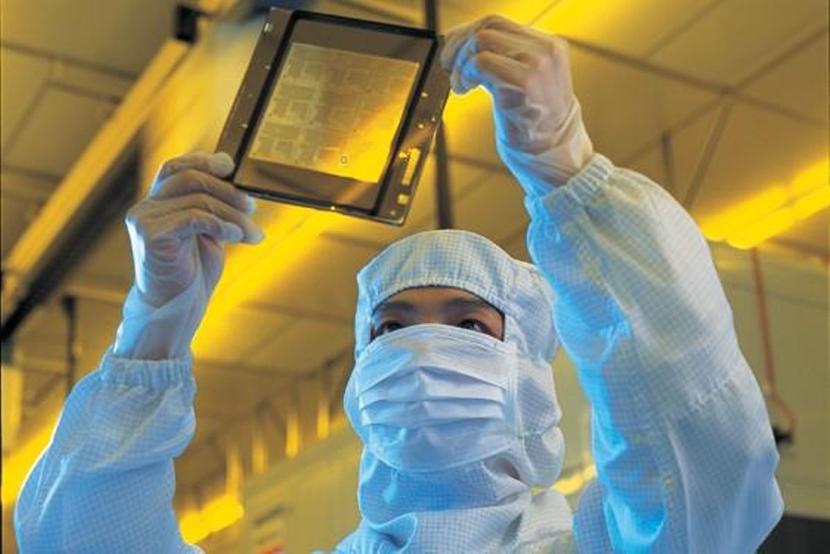 Trabajador de TSMC revisa una de las obleas producidas en la factoría taiwanesa. Trabajador de TSMC revisa una de las obleas producidas en la factoría taiwanesa.