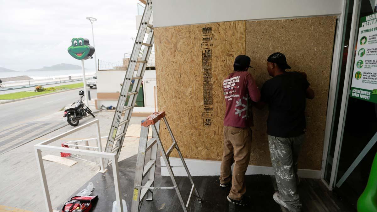 Trabajadores apuntalan la ventana de un restaurante ante la llegada del huracán ’Pamela’, en la ciudad mexicana de Mazatlan