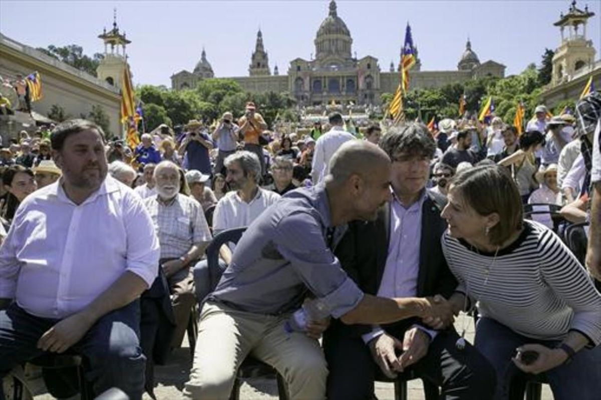 Guardiola saluda a Forcadell en presencia de Puigdemont y Junqueras, en el acto de Montjuïc en el que actuó como portavoz soberanista. Guardiola saluda a Forcadell en presencia de Puigdemont y Junqueras, en el acto de Montjuïc en el que actuó como portavoz soberanista.