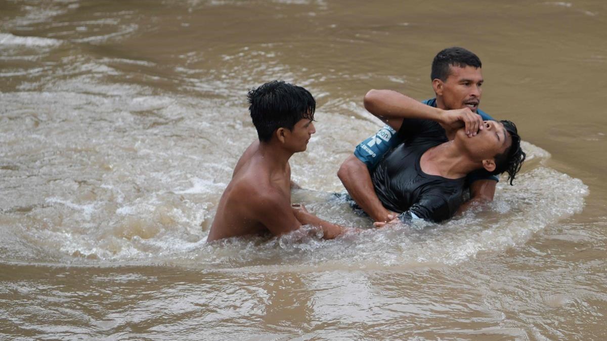 Migrantes hondureños tratan de cruzar el río Goascarán para ingresar en El Salvador de manera clandestina. 