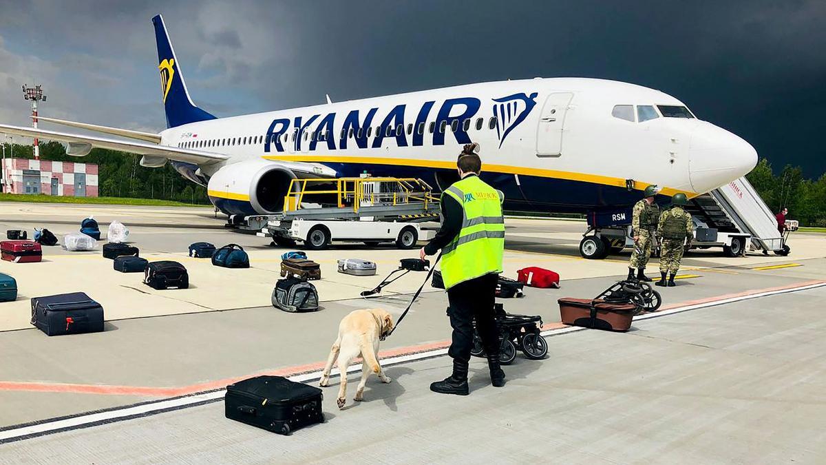 A Belarusian dog handler checks luggages off a Ryanair Boeing 737-8AS (flight number FR4978) parked on Minsk International Airport’s apron in Minsk, on May 23, 2021. - Belarusian opposition Telegram channel Nexta said Sunday its former editor and exiled opposition activist Roman Protasevich had been detained at Minsk airport after his Lithuania-bound flight made an emergency landing. Protasevich was travelling aboard a Ryanair flight from Athens to Vilnius, which made an emergency landing following a bomb scare, TASS news agency reported citing the press service of Minsk airport. The plane was checked, no bomb was found and all passengers were sent for another security search, Nexta said. Among them was... Nexta journalist Roman Protasevich. He was detained. (Photo by - / ONLINER.BY / AFP) / RESTRICTED TO EDITORIAL USE - MANDATORY CREDIT AFP PHOTO / ONLINER.BY  - NO MARKETING - NO ADVERTISING CAMPAIGNS - DISTRIBUTED AS A SERVICE TO CLIENTS