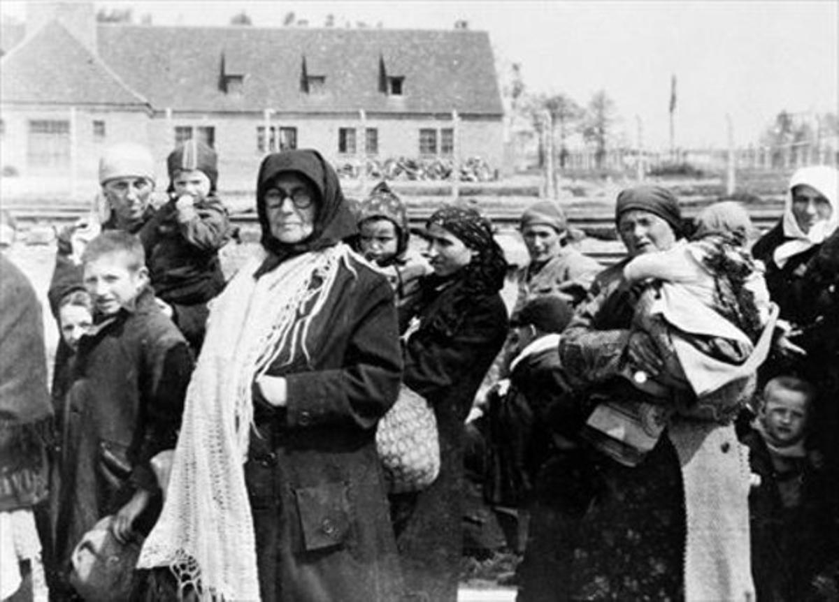 Mujeres y niños esperan ante el crematorio de Birkenau antes de entrar en la cámara de gas, en mayo de 1944.