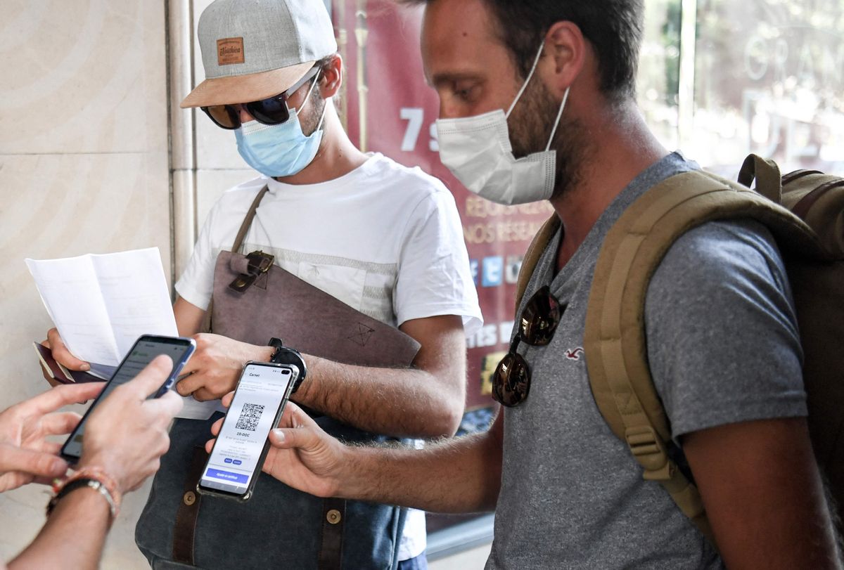 Dos hombres muestran su pasaporte sanitario a la entrada a un cine de Paris. Dos hombres muestran su pasaporte sanitario a la entrada a un cine de Paris.