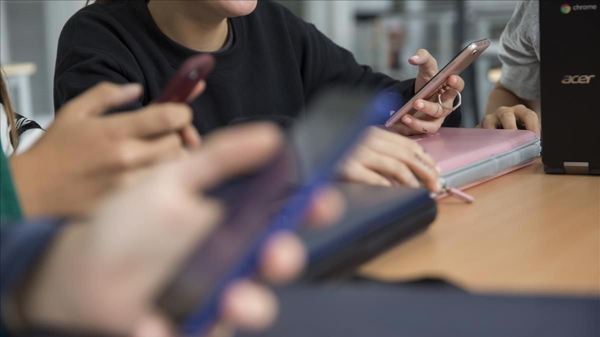 Jóvenes mirando el teléfono móvil Jóvenes mirando el teléfono móvil