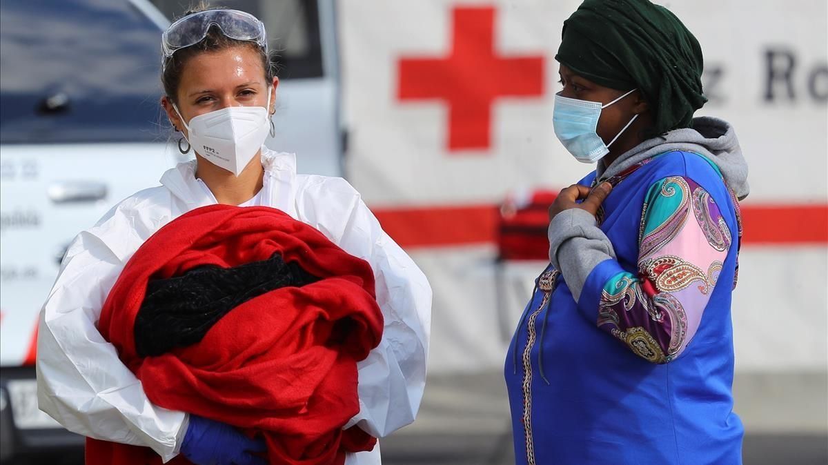 La bebé nacida en plena travesía, en brazos de una sanitaria y junto a su madre, en el puerto grancanario de Arguineguin. La bebé nacida en plena travesía, en brazos de una sanitaria y junto a su madre, en el puerto grancanario de Arguineguin.