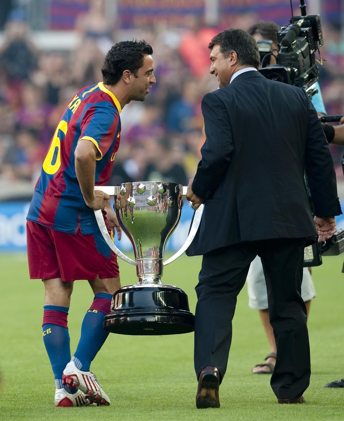 Xavi y Laporta pasean el trofeo de la Liga por el Camp Nou.