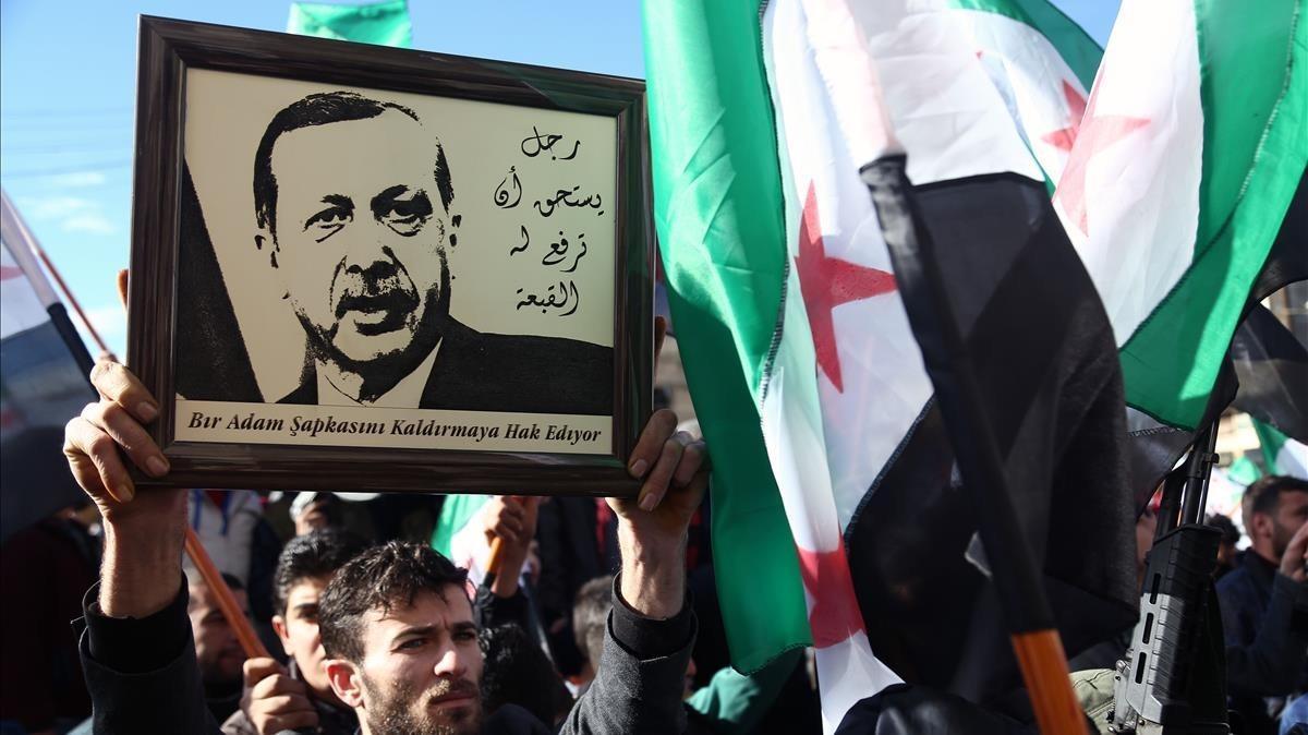 Simpatizantes de los rebeldes sirios levantan un retrato de Erdogan en apoyo de la operación turca contra las milicias kurdas, este viernes en Azaz (Siria). Simpatizantes de los rebeldes sirios levantan un retrato de Erdogan en apoyo de la operación turca contra las milicias kurdas, este viernes en Azaz (Siria).