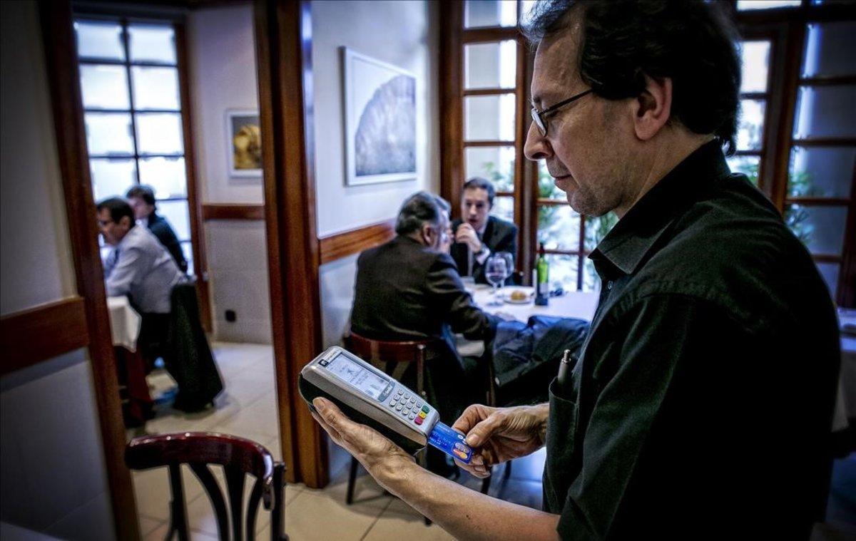 Un camarero cobra una cuenta en un restaurante de Barcelona.