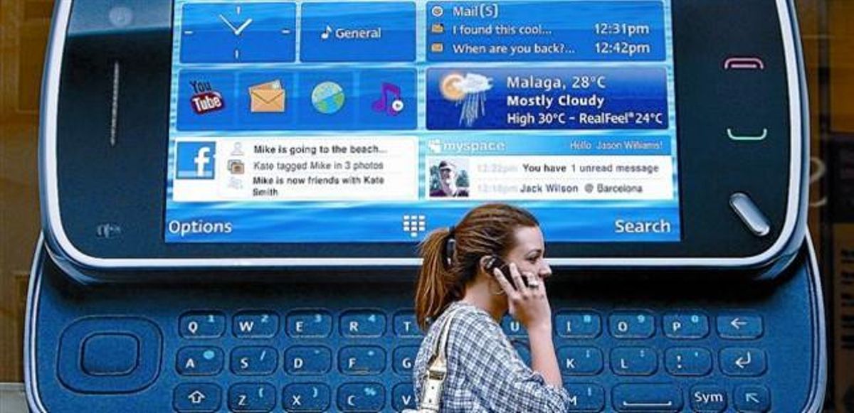 Una ciudadana londinense pasa ante un anuncio de un teléfono inteligente de Nokia. Una ciudadana londinense pasa ante un anuncio de un teléfono inteligente de Nokia.