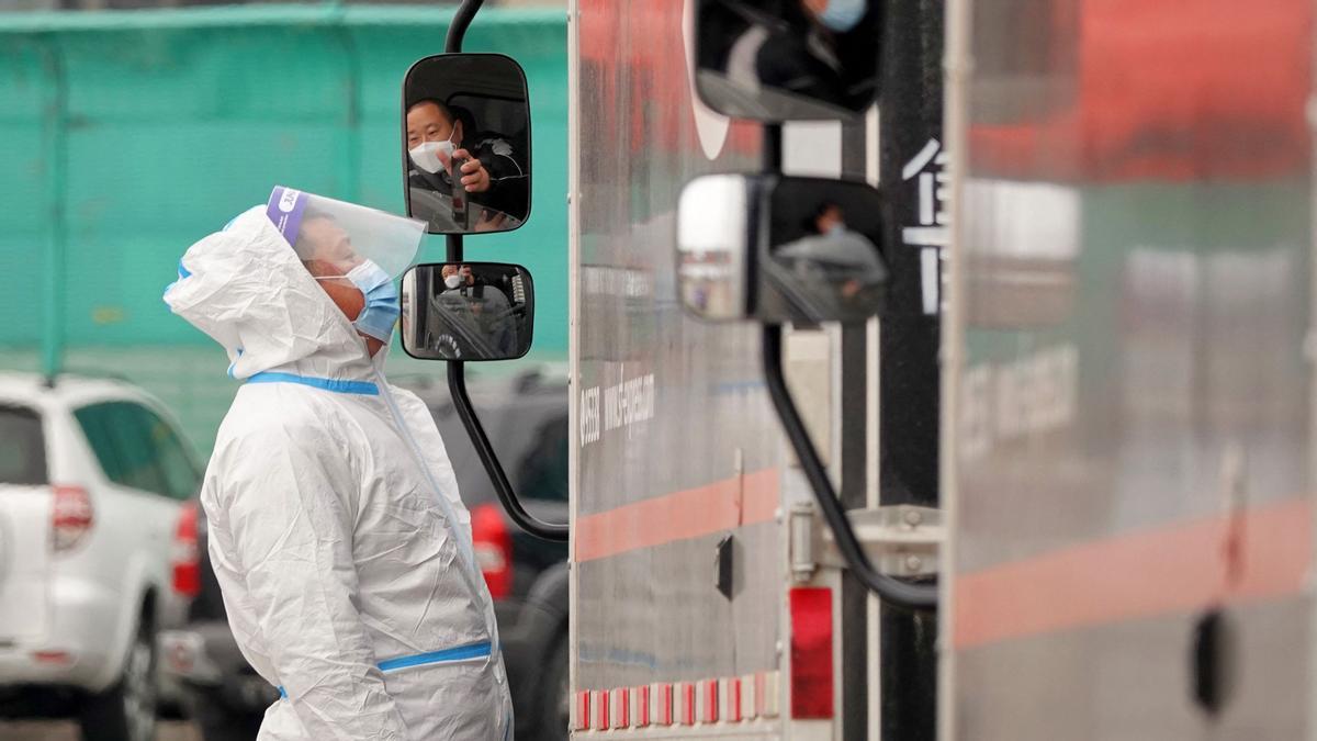 Personal equipado con trajes de protección supervisa el estado de salud de un conductor en la provincia de Shandong
