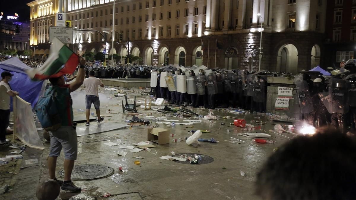 Manifestantes lanzan botellas contra la policía durante una protesta en Sofia. Manifestantes lanzan botellas contra la policía durante una protesta en Sofia.