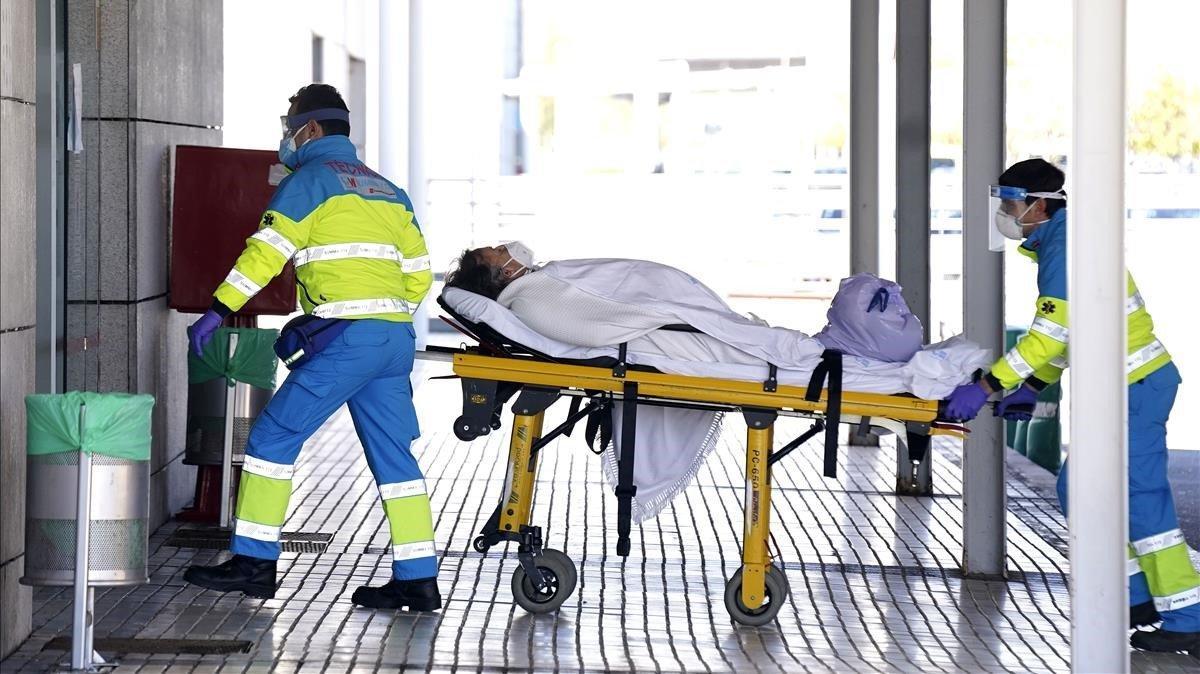 Enfermeros trasladan a una mujer mayor con coronavirus a Urgencias del Hospital Puerta de Hierro en Majadahonda, Madrid.