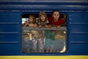 Varios niños escapan en un tren de las zonas devastadas del Donbás. 