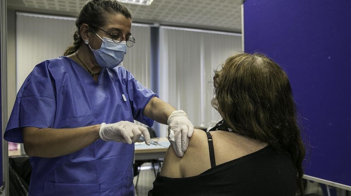 Una mujer recibe la vacuna de AstraZeneca en el centro de vacunación instalado en la facultad de Geografía e Historia de la UB. Una mujer recibe la vacuna de AstraZeneca en el centro de vacunación instalado en la facultad de Geografía e Historia de la UB.