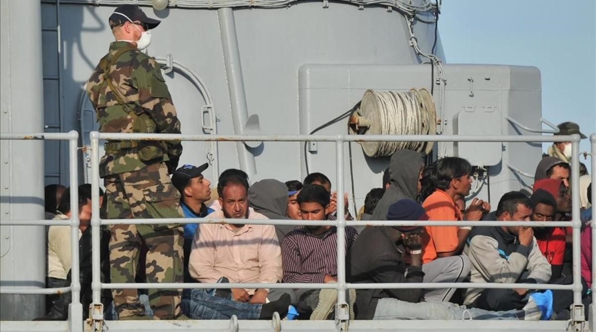 Migrantes en la cubierta de un barco militar francés, a su llegada al puerto de Crotone, en el sur de Italia, tras una operación de rescate de la misión conjunta Tritón, el 3 de mayo del 2015. Migrantes en la cubierta de un barco militar francés, a su llegada al puerto de Crotone, en el sur de Italia, tras una operación de rescate de la misión conjunta Tritón, el 3 de mayo del 2015.