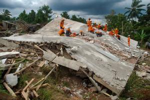 Trabajadores de los servicios de emergencia buscan a las posibles víctimas atrapadas bajo las ruinas de un edificio en Cianjur (Indonesia). 