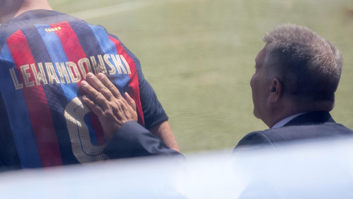 El presidente Joan Laporta da una palmada en la espalda de Robert Lewandowski en el momento de salir al césped del Camp Nou.