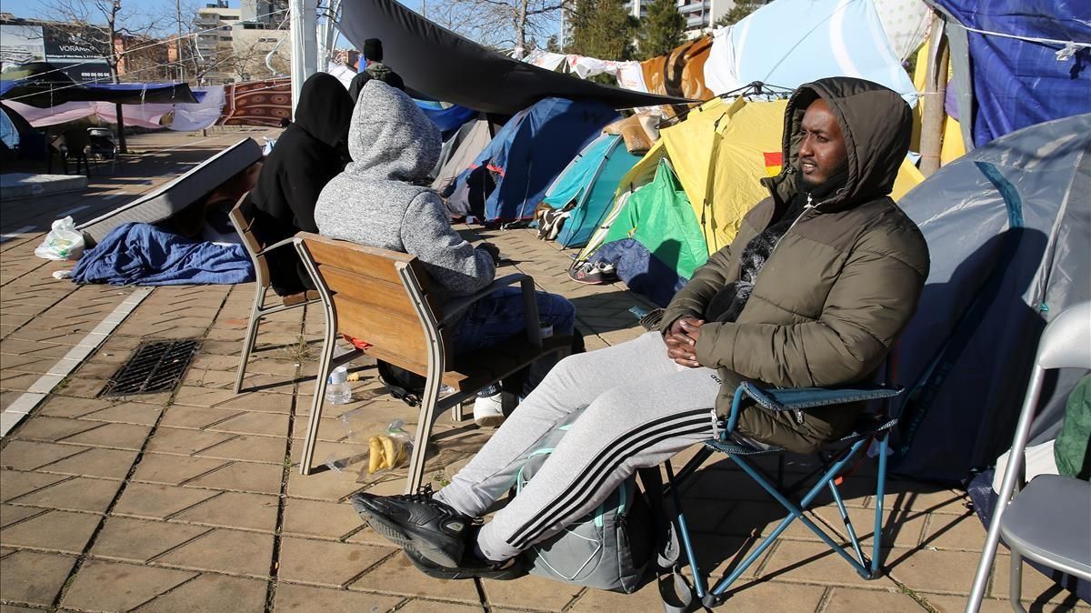Tensa espera en el campamento de migrantes situado en plena calle, en Badalona Tensa espera en el campamento de migrantes situado en plena calle, en Badalona
