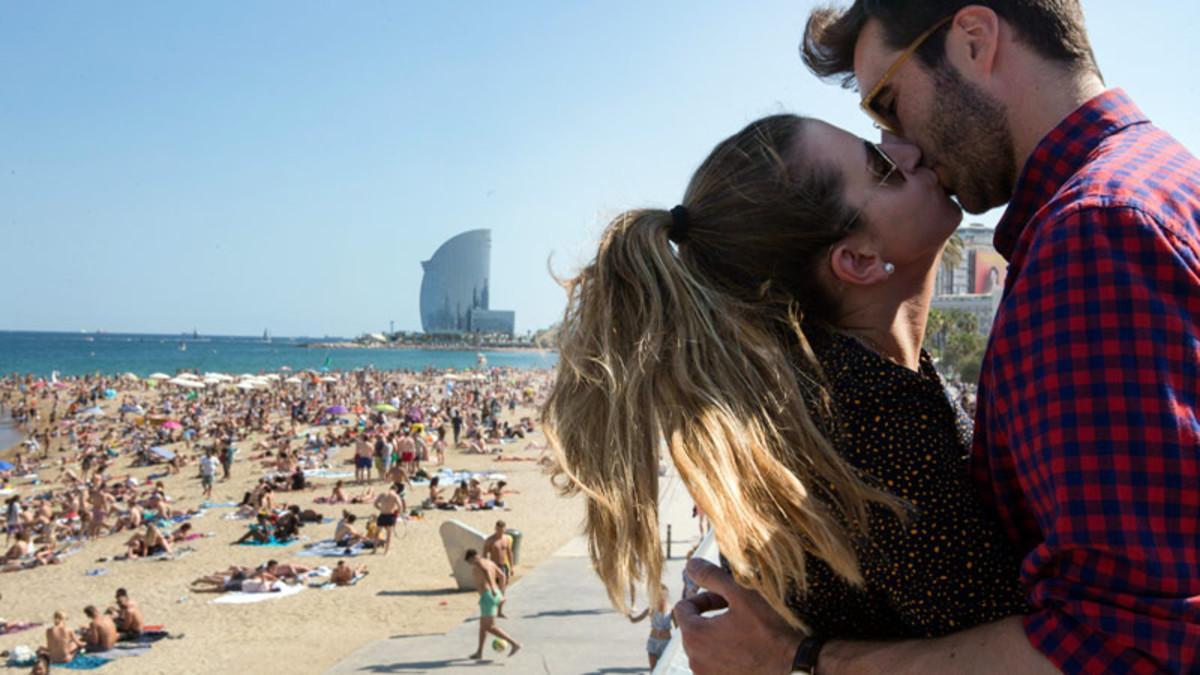 SOLSTICIO DE VERANO. Una pareja se besa junto a la playa, en Barcelona.
