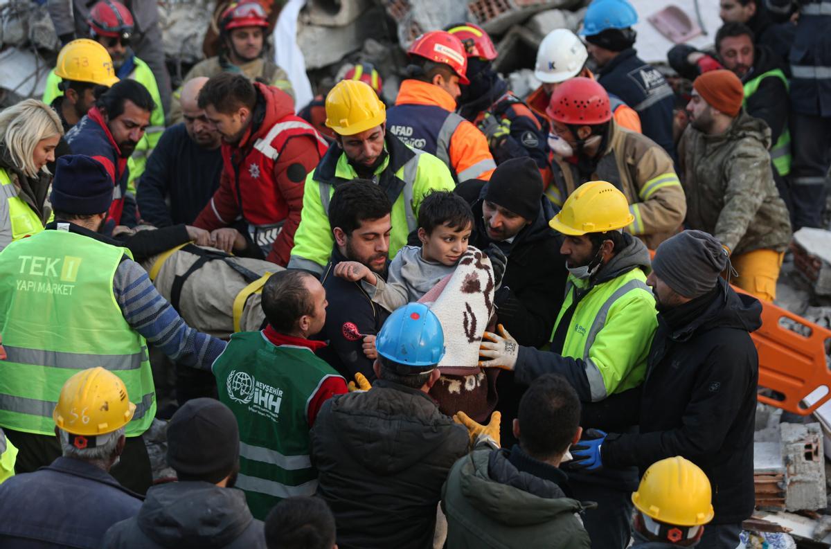 Equipos de búsqueda y de rescate evacúan a un niño y a sus padres de los escombros de un edificio devastado por el terremoto en la ciudad de Hatay, al sureste de Turquía.