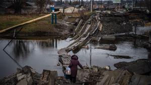 Una mujer cruza un puente destruido en Bajmut, región de Donetsk, el 6 de enero de 2023, en medio de la invasión rusa de Ucrania.