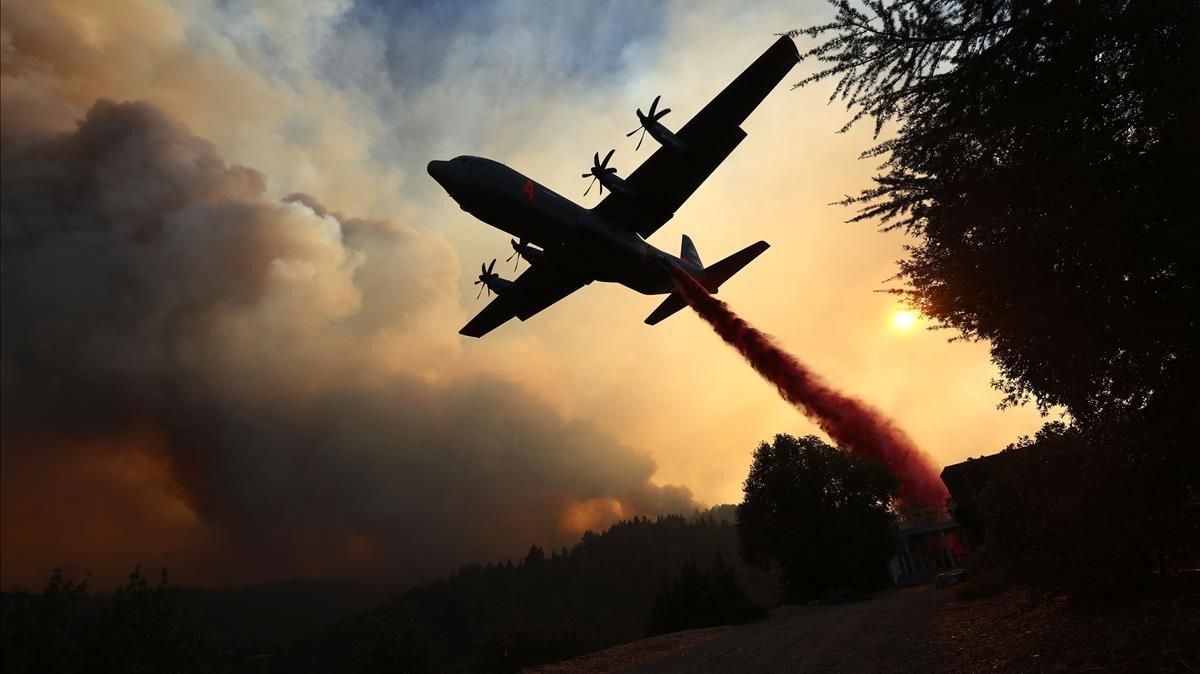 Un avión intenta contener las llamas en California. Un avión intenta contener las llamas en California.