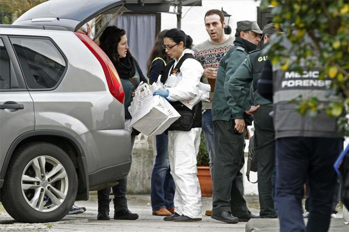 Agentes judiciales y de la Guardia Civil salen de una de las viviendas, en el municipio lucense de Cervo, donde encontraron dos cadáveres.