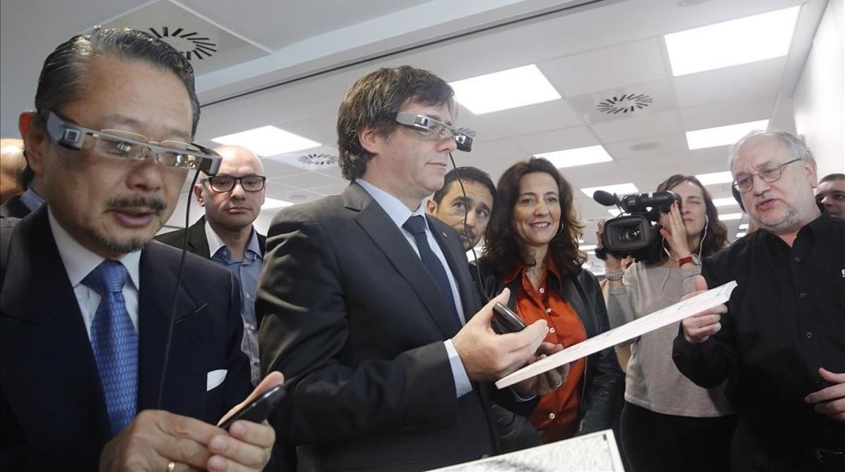 El ’president’ de la Generalitat, Carles Puigdemont, y el consul de Japón, Nahoito Watanave, con gafas virtuales en la nueva sede de Epson en Sant Cugat del Vallès. 