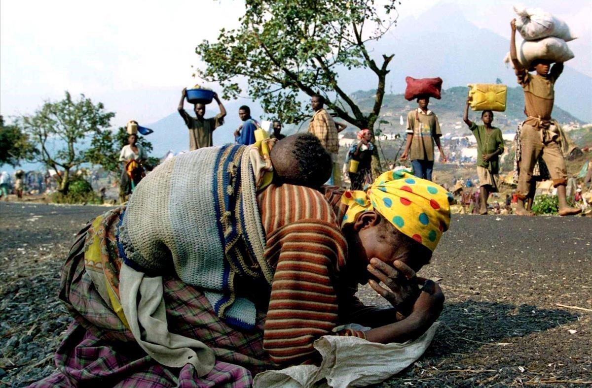 Una mujer ruandesa se derrumba ante la barbarie del entorno mientras camina con su bebé a cuestas en la carrtera que comunicaba los campo de refugiados de Kibumba y Goma. Los planes del Ejecutivo ruandés se saldaron con la eliminación de tres de cada cuatro tutsis. 