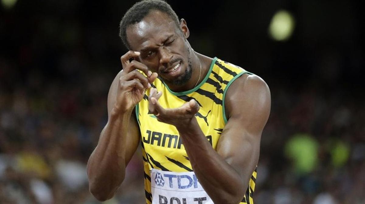 Usain Bolt simula tomar una foto antes de la salida de 200.