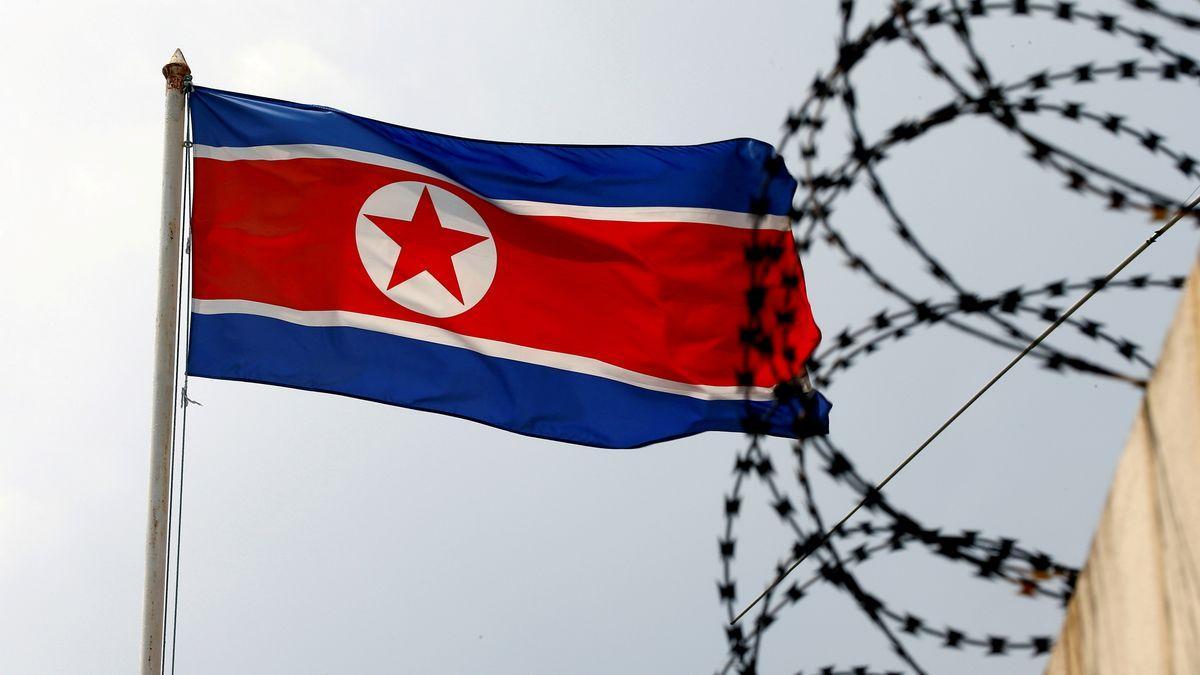 Una bandera de Corea del Norte ondea junto a la concertina que rodea la propia embajada del país