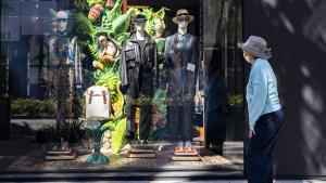 Mujer en Estados Unidos mirando el aparador de una tienda de ropa, durante la pandemia.