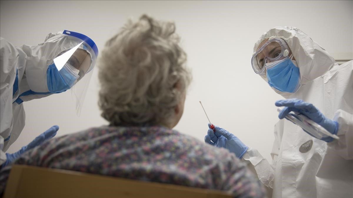 Enfermeras de atención primaria realizan un test PCR a una mujer en Barcelona, el pasado mayo.