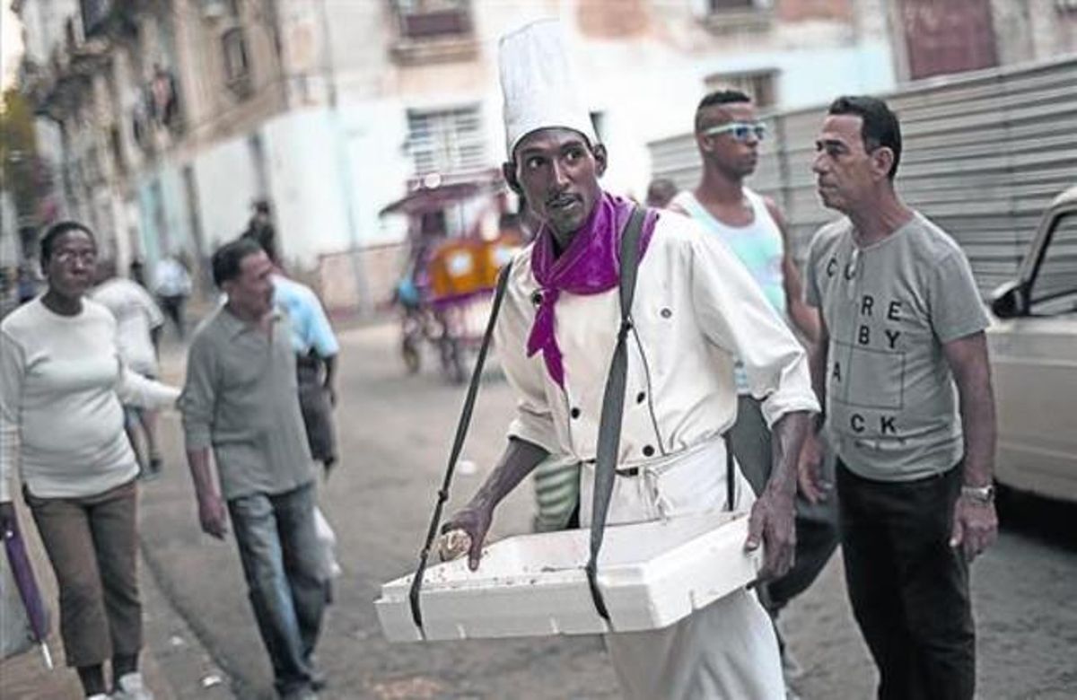 El deshielo afecta poco a los habaneros, de momento. Arriba, los turistas montan en un vehículo de los años 50 mil veces reparado y decorado con el rostro del Che Guevara . Sobre estas líneas, a la izquierda, tres ciudadanos aguardan en la ’bodega’ para comprar vegetales ante la foto de Fidel Castro (izquierda), y un vendedor ambulante ofrece unas pastitas llamadas ’Señoritas’ a los transeúntes. El deshielo afecta poco a los habaneros, de momento. Arriba, los turistas montan en un vehículo de los años 50 mil veces reparado y decorado con el rostro del Che Guevara . Sobre estas líneas, a la izquierda, tres ciudadanos aguardan en la ’bodega’ para comprar vegetales ante la foto de Fidel Castro (izquierda), y un vendedor ambulante ofrece unas pastitas llamadas ’Señoritas’ a los transeúntes.