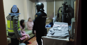 Agentes de la Policía Nacional entran en uno de los pisos de prostitución desmantelados en Zaragoza, donde mujeres chinas eran explotadas por una red de trata de seres humanos.