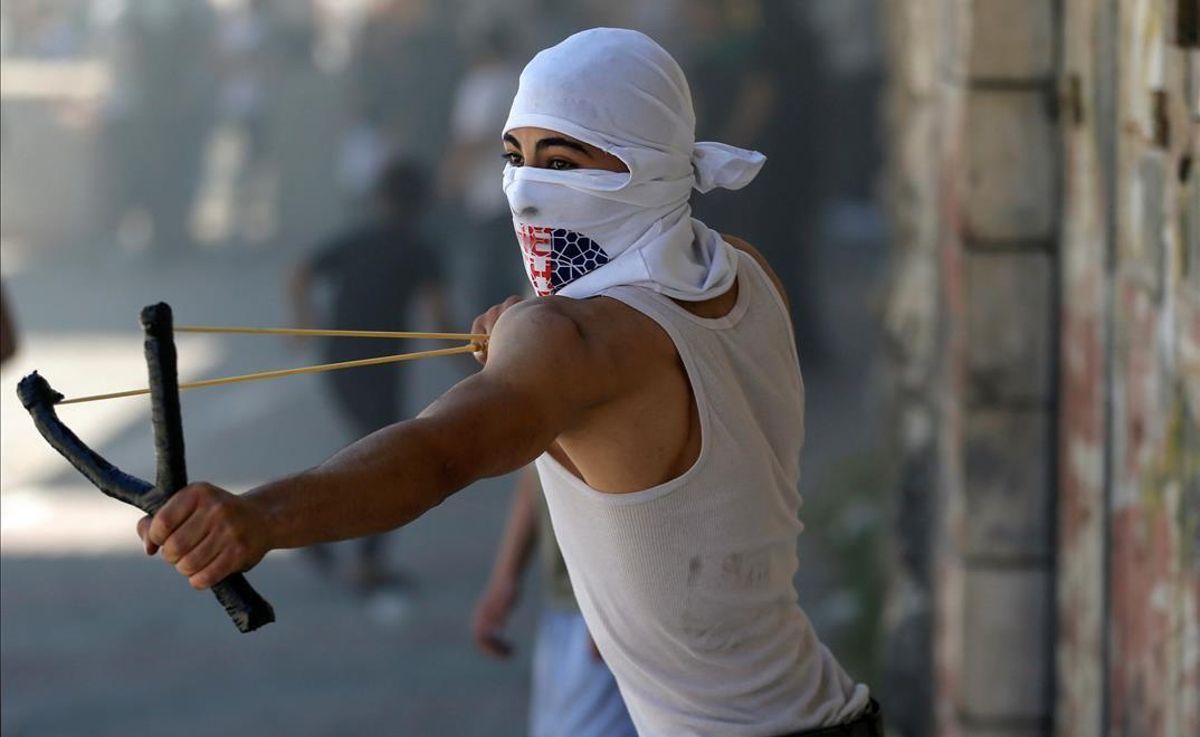 Un manifestante palesino lanza piedras a las fuerzas israelís durante las protestas en Hebrón Un manifestante palesino lanza piedras a las fuerzas israelís durante las protestas en Hebrón