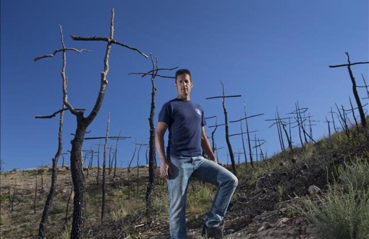 El bombero y artista Marc Sellarès en el bosque de cruces que ha creado en la zona del incendio de Ódena.
