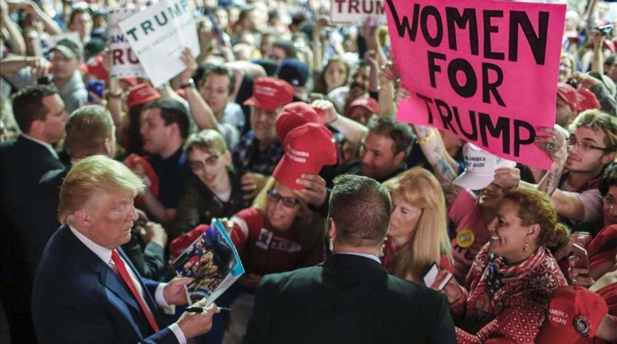 Trump (izq) firma fotos y sombreros tras hablar ante sus seguidores en un centro cívico de Pougkeepsie (Nueva York), el día 17.