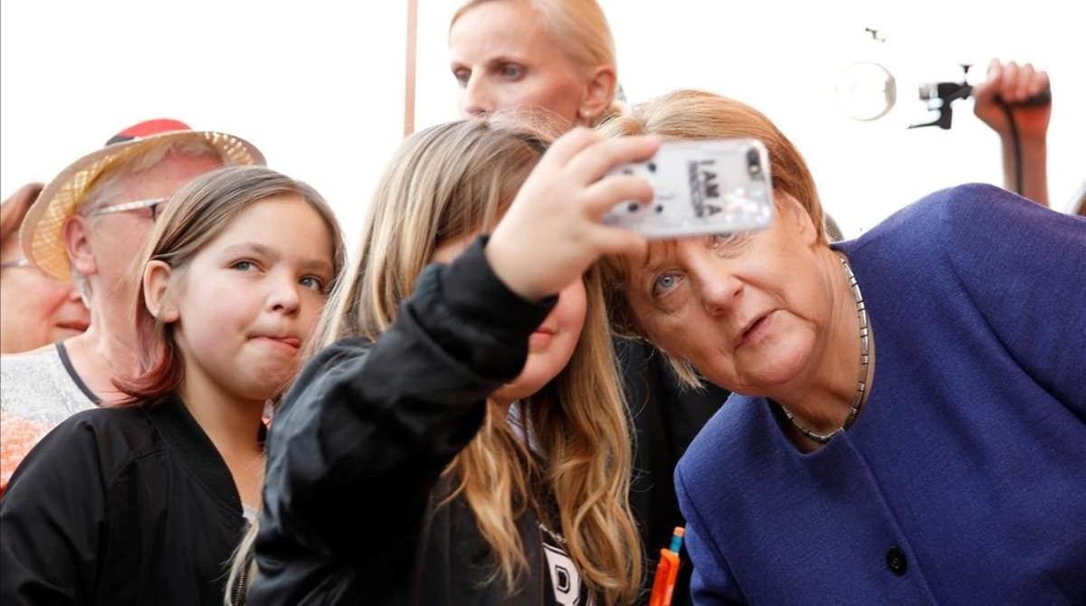 La cancillera alemana, Angela Merkel, se hace un selfi con una seguidora.