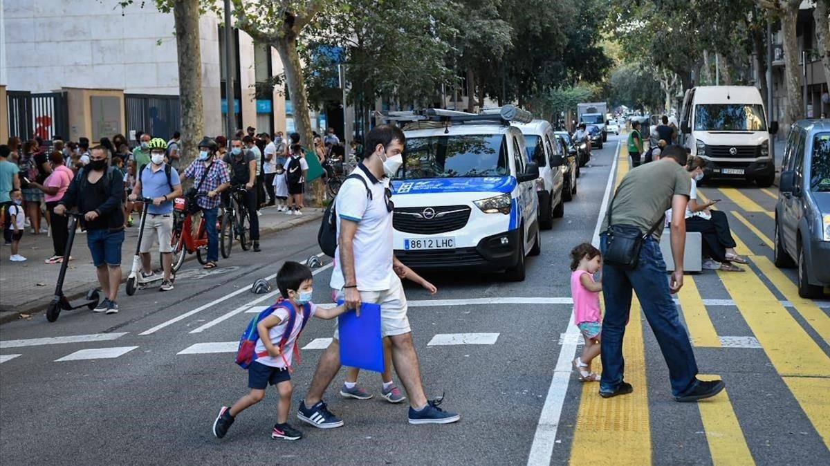 Padres llevando a sus hijos a la escuela en el primer día de clase. Padres llevando a sus hijos a la escuela en el primer día de clase.