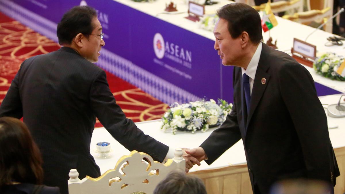 El primer ministro japonés, Fumio Kishida, y el presidente surcoreano, Yoon Suk-yeol, se dan la mano este domingo en Camboya.