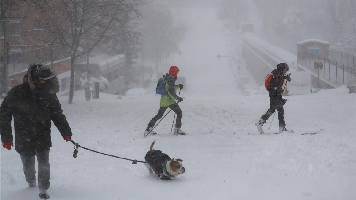 Viandantes en una calle cubierta de nieve en Madrid este sábado La Comunidad de Madrid ha despertado este sabado cubierta con una espesa manta de nieve Viandantes en una calle cubierta de nieve en Madrid este sábado La Comunidad de Madrid ha despertado este sabado cubierta con una espesa manta de nieve