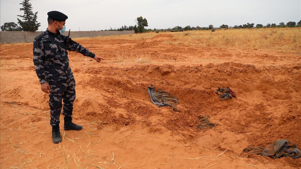 Un miembro de las fuerzas de seguridad leales al GNA señala una de las fosas comunes halladas en Libia en la ciudad de Tarhuna.