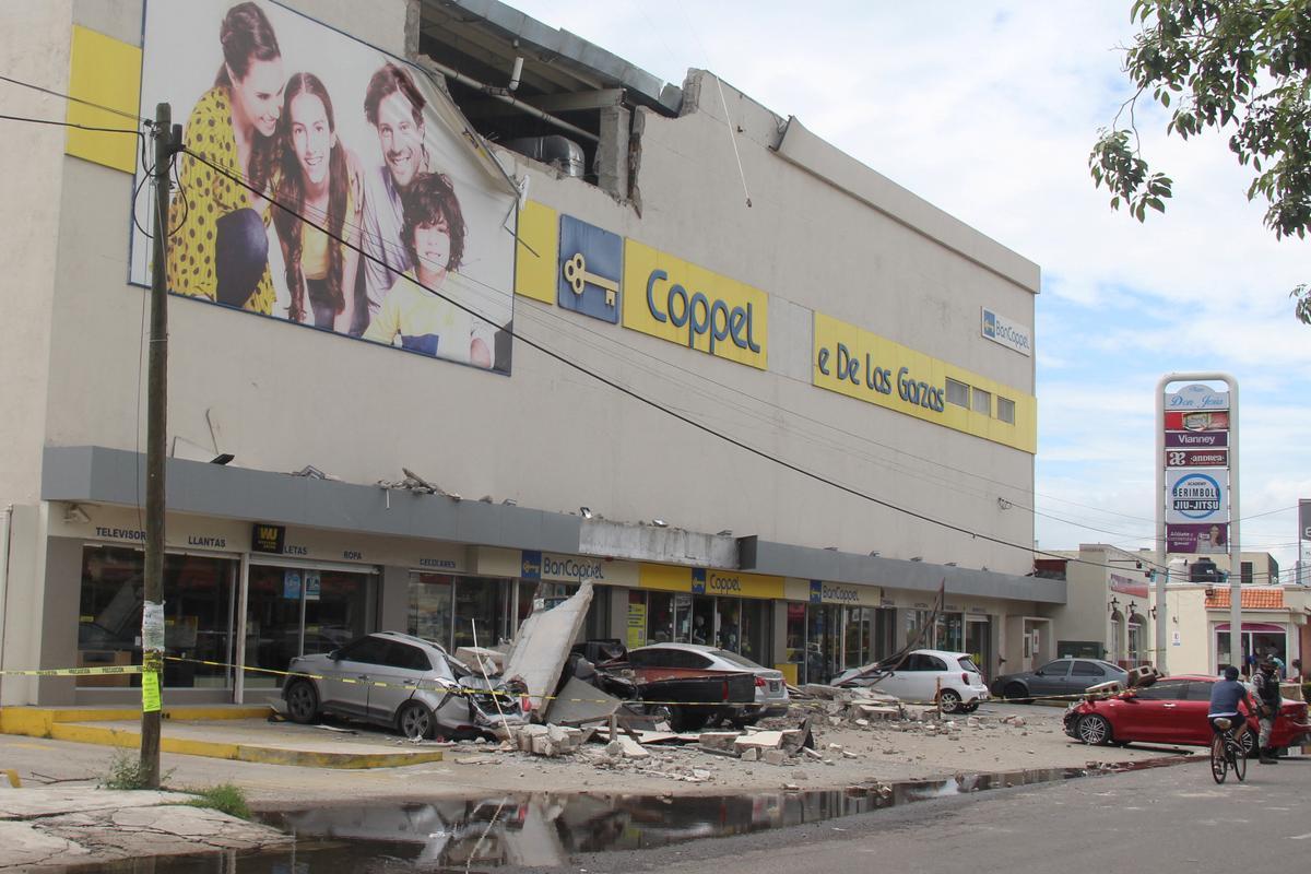 Vehículos dañados por el derrumbe de la fachada de un edificio en la localidad de Manzanillo a causa del terremoto que se registró el 19 de septiembre en México. 
