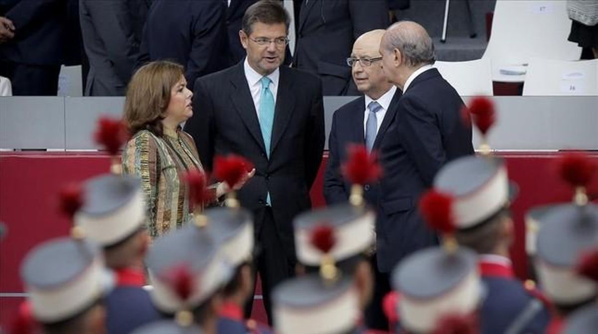 Cristóbal Montoro conversa con la vicepresidenta, Soraya Sáenz de Santamaría, y los ministros Rafael Catalá y Jorge Fernandez Diaz, durante el desfile del Día de la Hispanidad. Cristóbal Montoro conversa con la vicepresidenta, Soraya Sáenz de Santamaría, y los ministros Rafael Catalá y Jorge Fernandez Diaz, durante el desfile del Día de la Hispanidad.